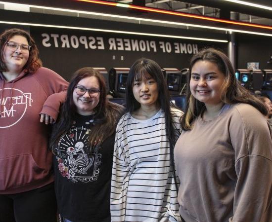 The four members of the first all-female eSports team at Utica University stands shoulder to shouler.
